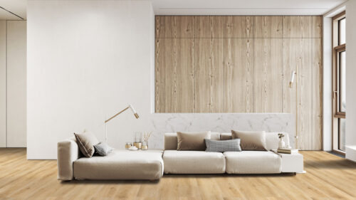 Prestige Laminate Forked Creek flooring in a modern living room in Atlanta, Georgia, featuring a modular sofa, light wood paneling, and white walls, highlighting the laminate's natural wood look and suitability for contemporary interiors in Atlanta.