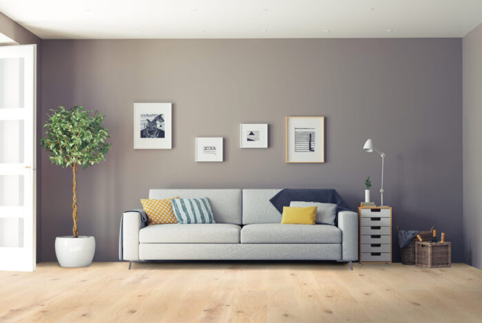 Modern living room with light hardwood flooring, gray sofa, and minimalist decor – premium wood floors by Rustic Wood Floor Supply.