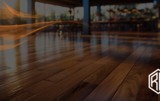 Close-up of polished hardwood planks in warm and cool tones with a soft light swirl overlay in a modern interior, illustrating how to choose hardwood floor color
